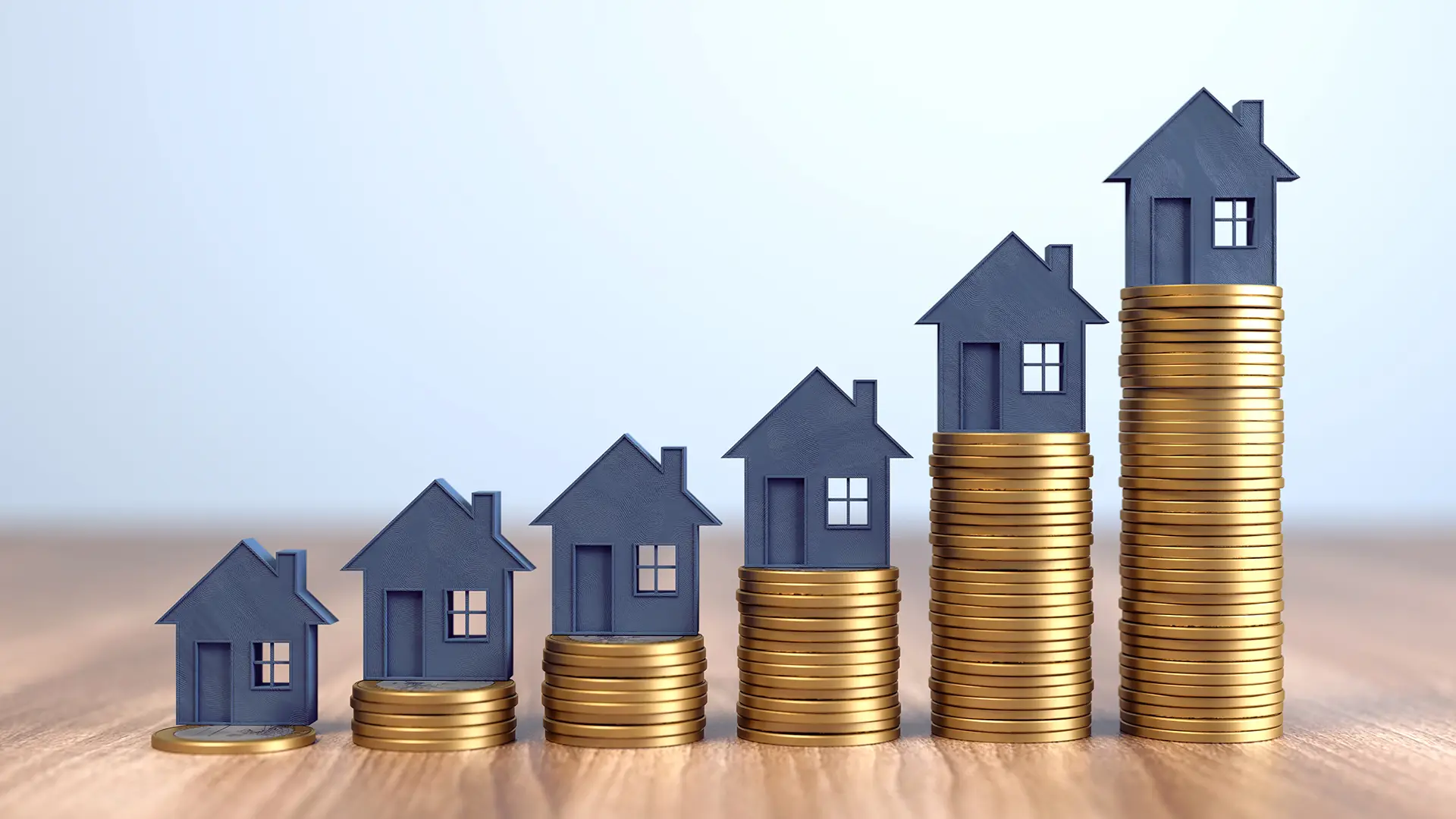 Croissance du patrimoine immobilier illustré par des piles de pièces avec une maison en haut de chacune des piles